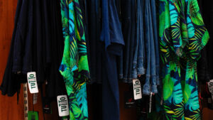 Camicie estive uomo taglie forti: stand con camicie a vistosa fantasia tropicale verde e azzurra.