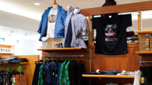 Abbigliamento uomo taglie forti casual: espositore con t-shirt stampate, camicie e bermuda estivi.