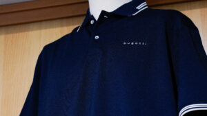 Polo uomo grandi taglie: dettaglio di una polo classica blu scuro con profili bianchi sul colletto.