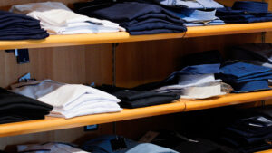 Camicie uomo taglie comode: ripiani con camicie estive piegate in cotone bianco e azzurro.
