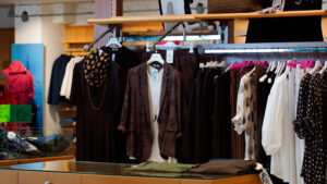 Moda curvy coordinati estivi: stand con pantaloni, bluse e giacche leggere in colori della terra.