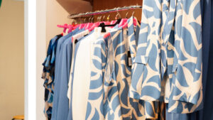 Abbigliamento curvy online: stand con abiti e bluse a motivi geometrici azzurri e bianchi.