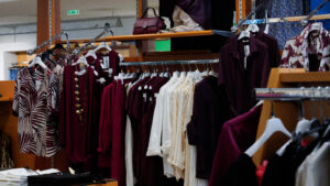 Moda donna taglie forti: stand con abiti a fantasia e capi bordeaux collezione primavera estate.