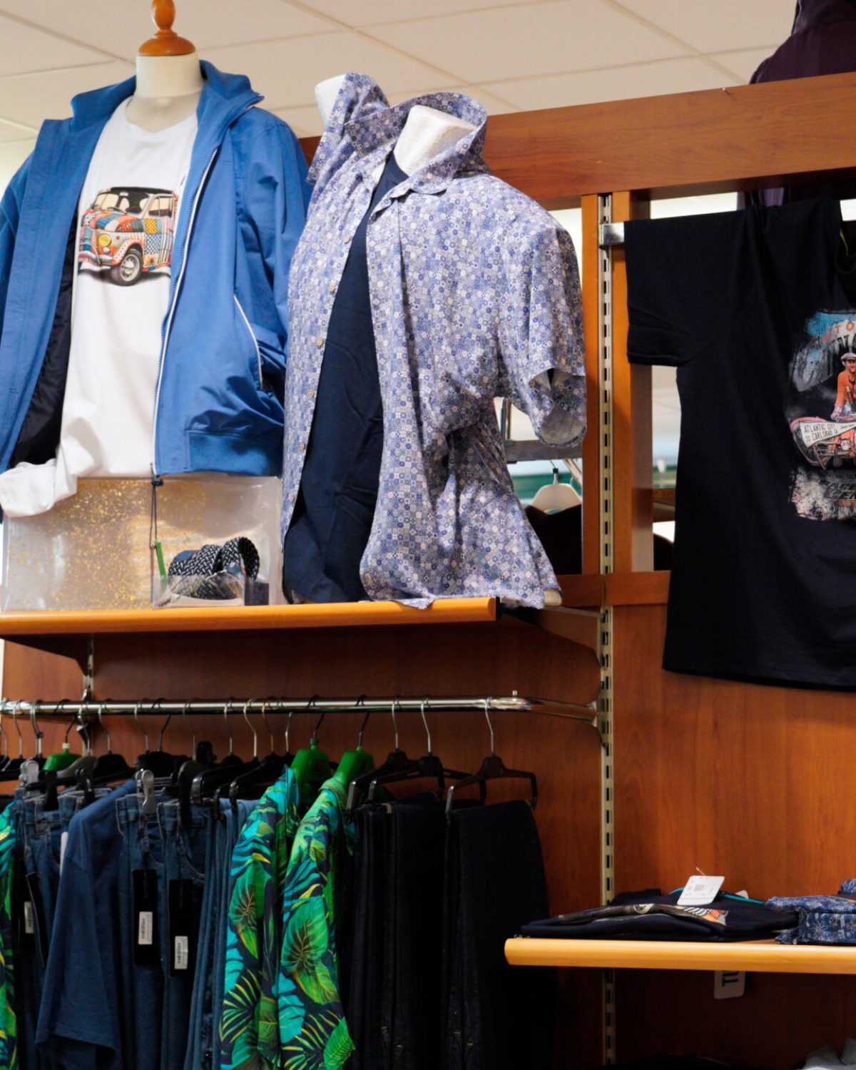 Abbigliamento uomo taglie forti casual: espositore con t-shirt stampate, camicie e bermuda estivi.