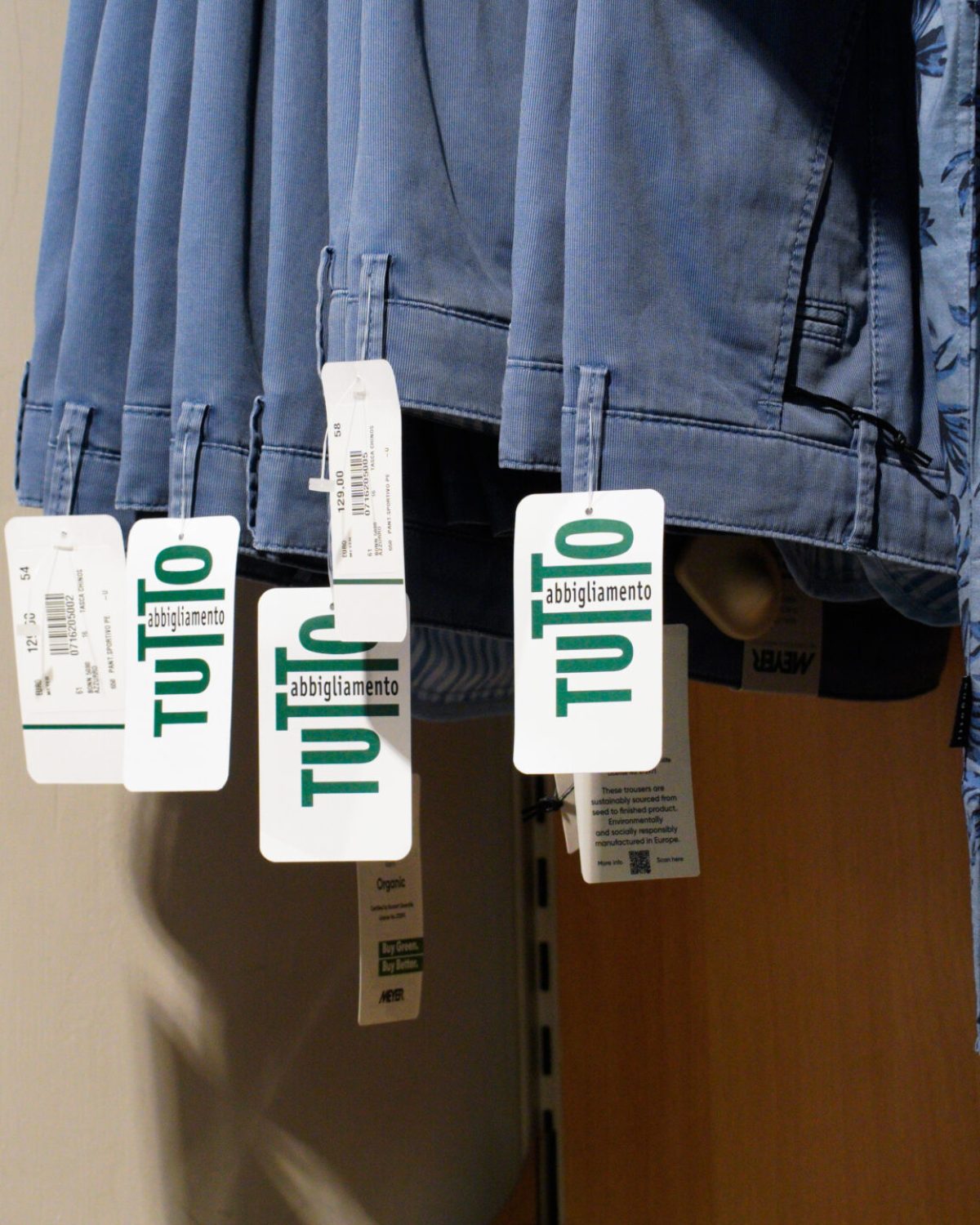 Jeans taglie comode uomo: dettaglio di pantaloni in denim appesi con cartellino Tutto Abbigliamento.