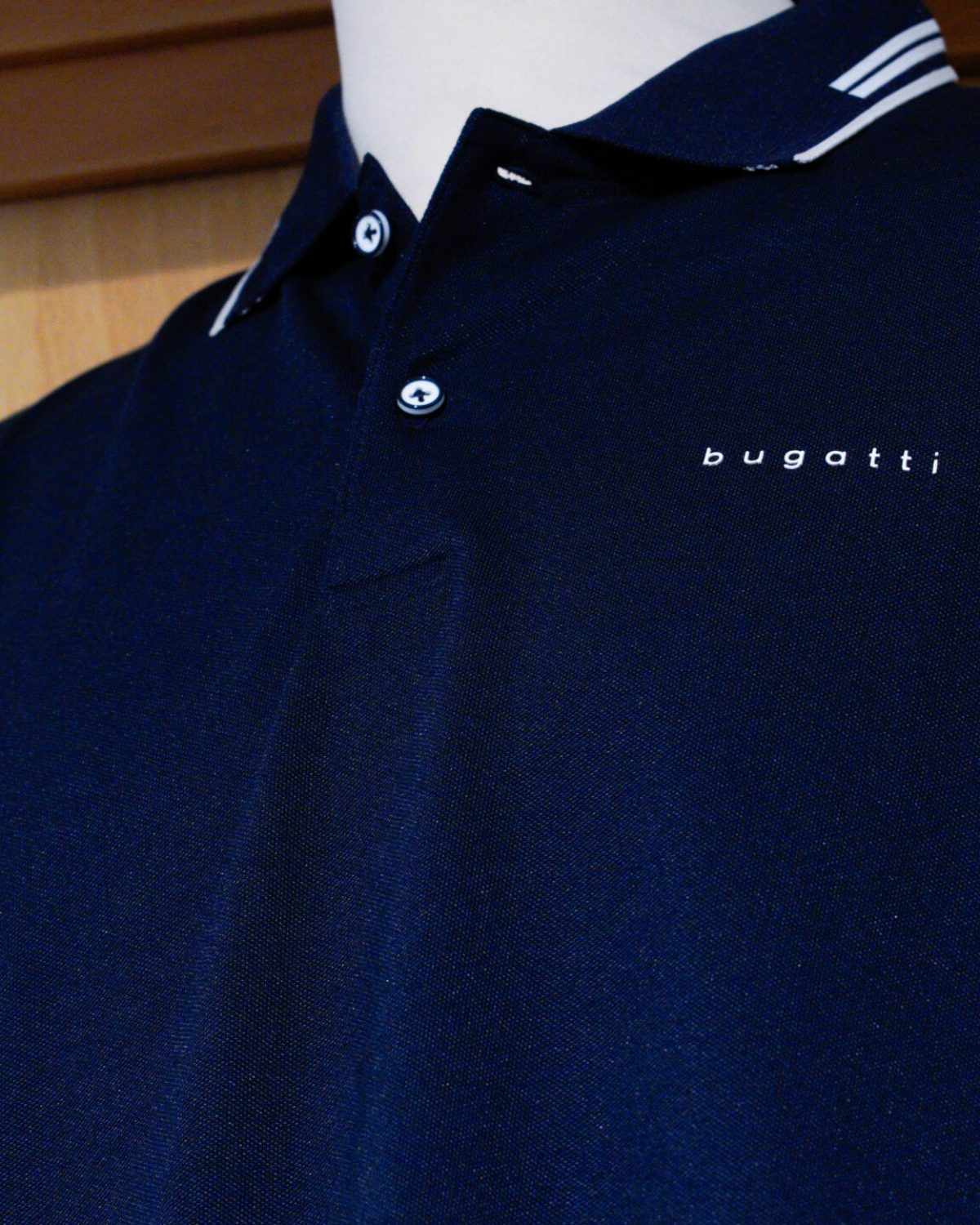 Polo uomo grandi taglie: dettaglio di una polo classica blu scuro con profili bianchi sul colletto.