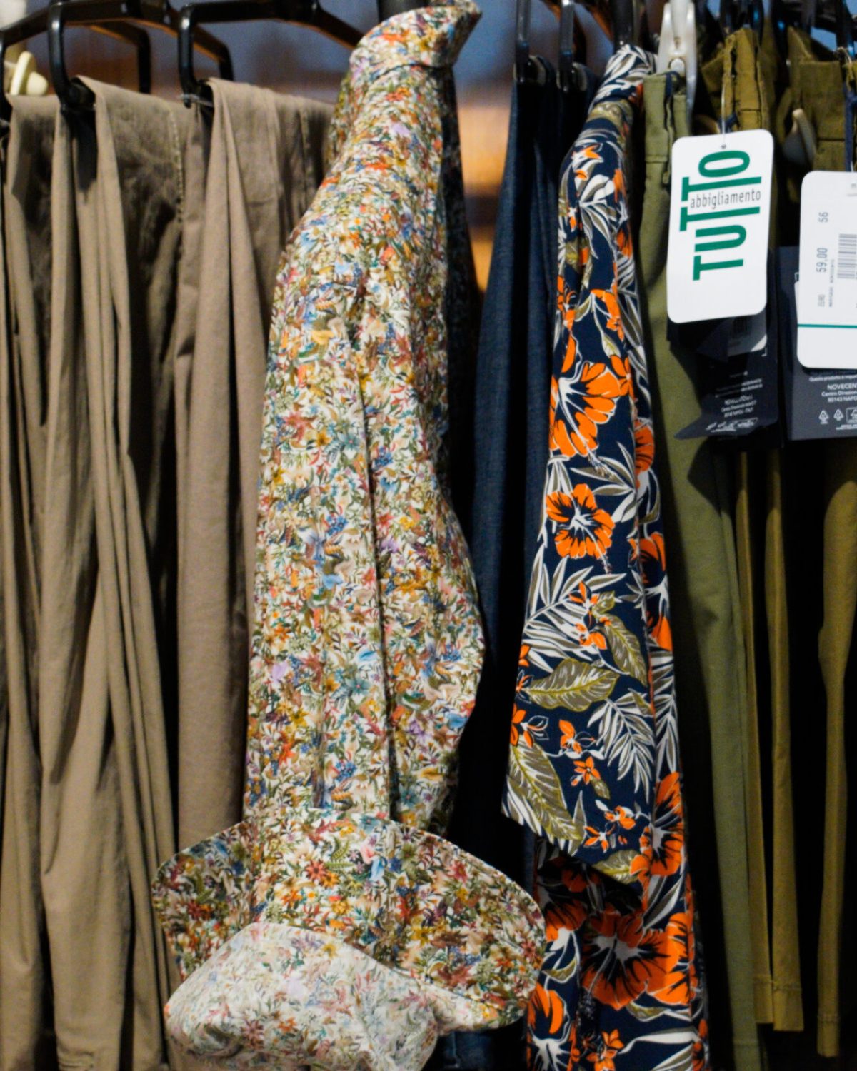 Abbigliamento casual uomo grandi taglie: stand con pantaloni cargo e camicie a fantasia estiva.