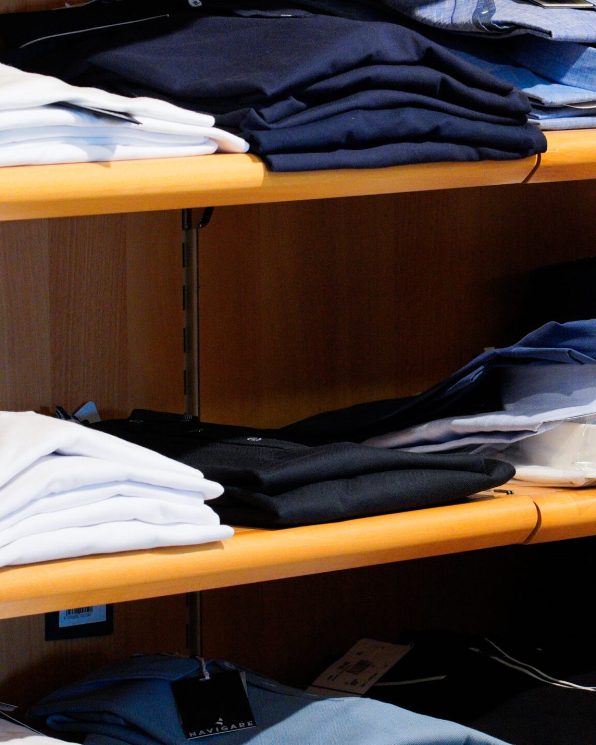 Camicie uomo taglie comode: ripiani con camicie estive piegate in cotone bianco e azzurro.