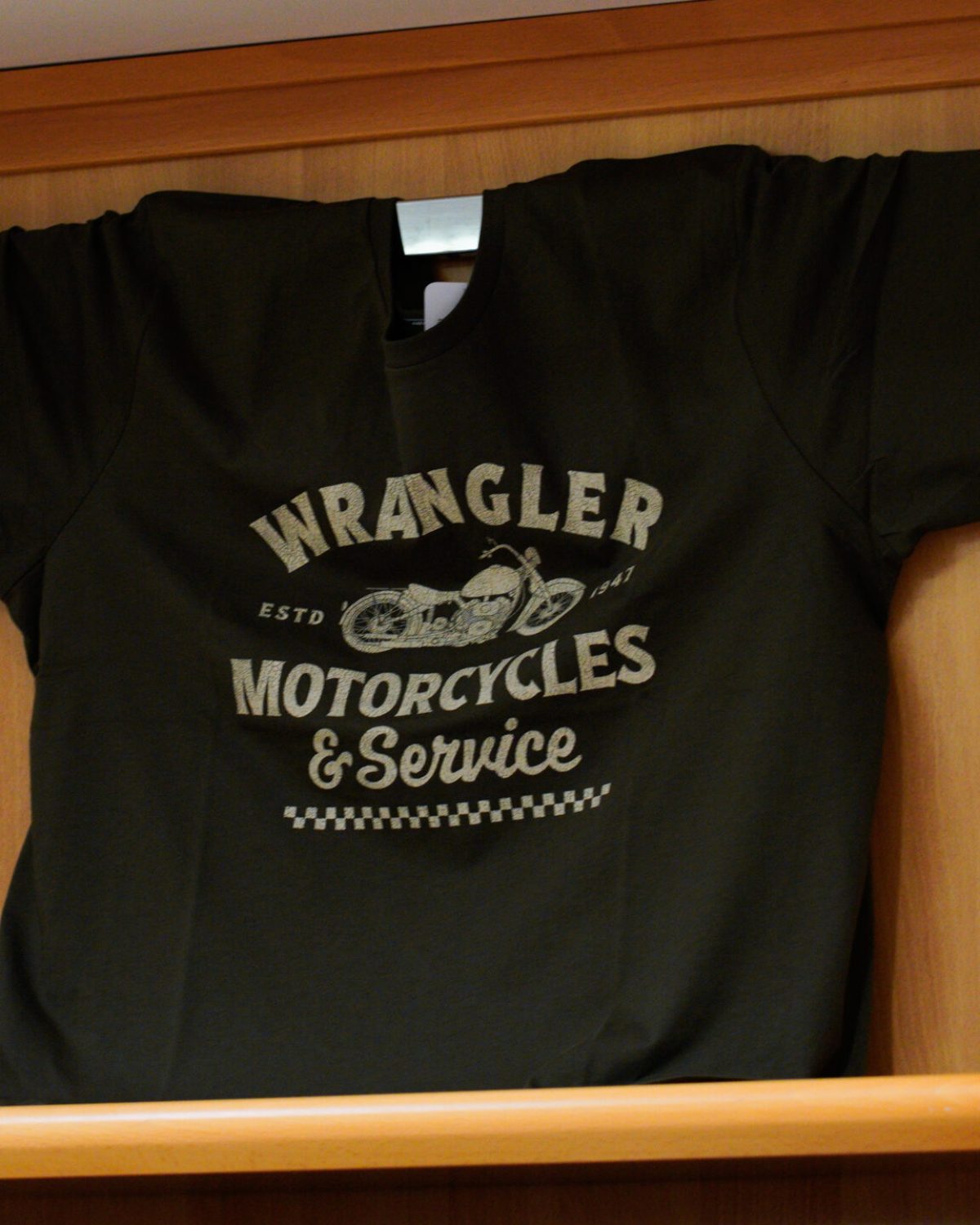 T-shirt uomo taglie comode: maglietta nera Wrangler con stampa vintage esposta in negozio.