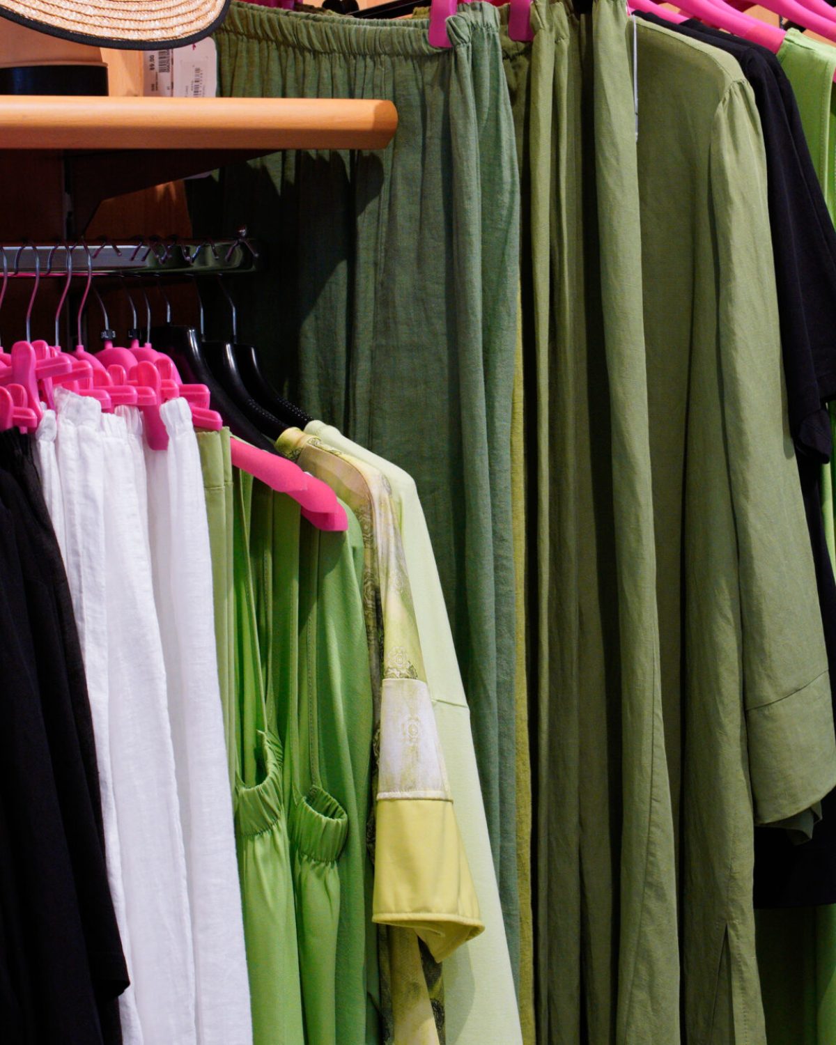 Completi donna taglie comode: stand con capi estivi verdi, neri e bianchi collezione SS26.