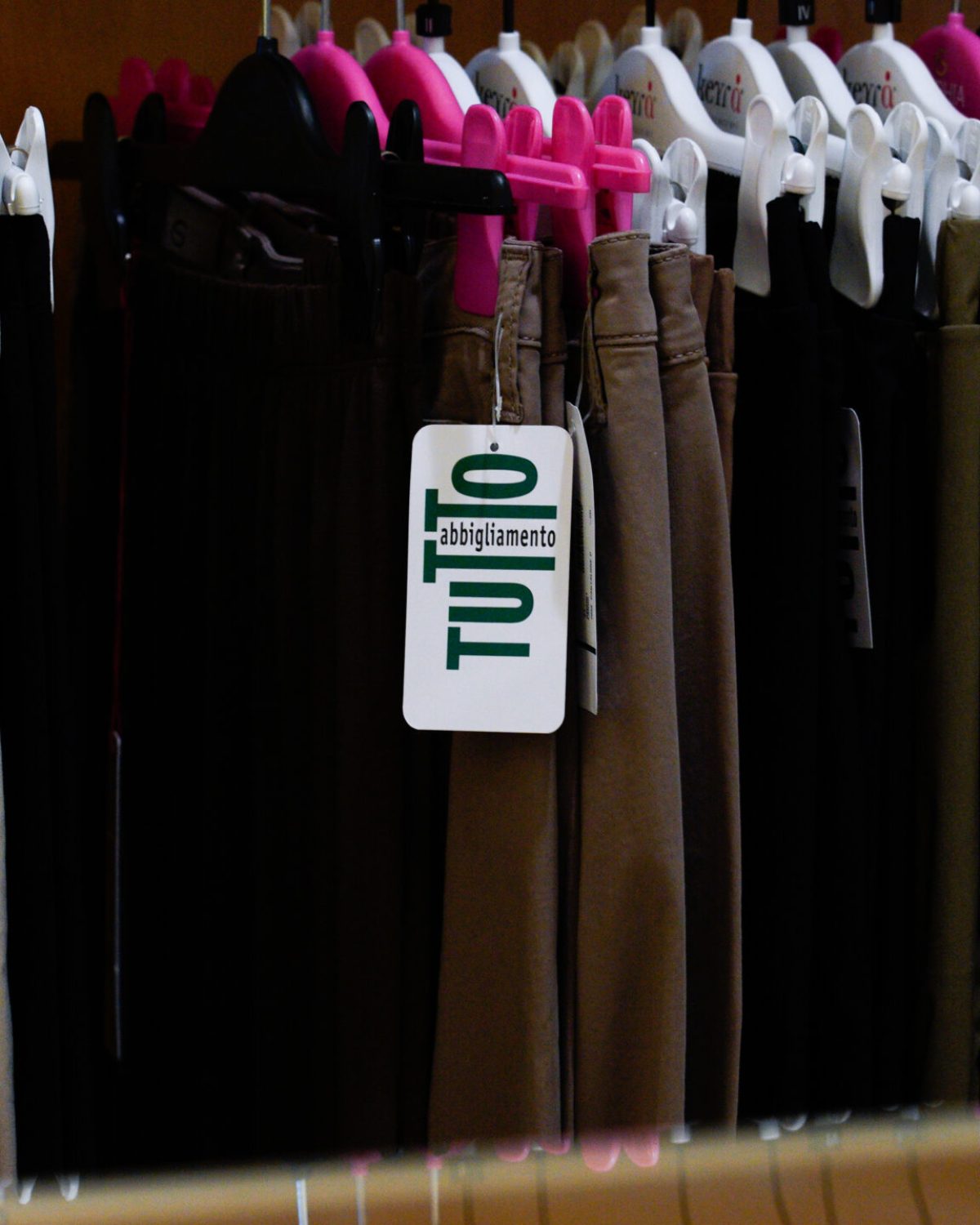 Abbigliamento taglie comode donna: pantaloni e gonne scure esposte nel reparto curvy a Occhiobello.